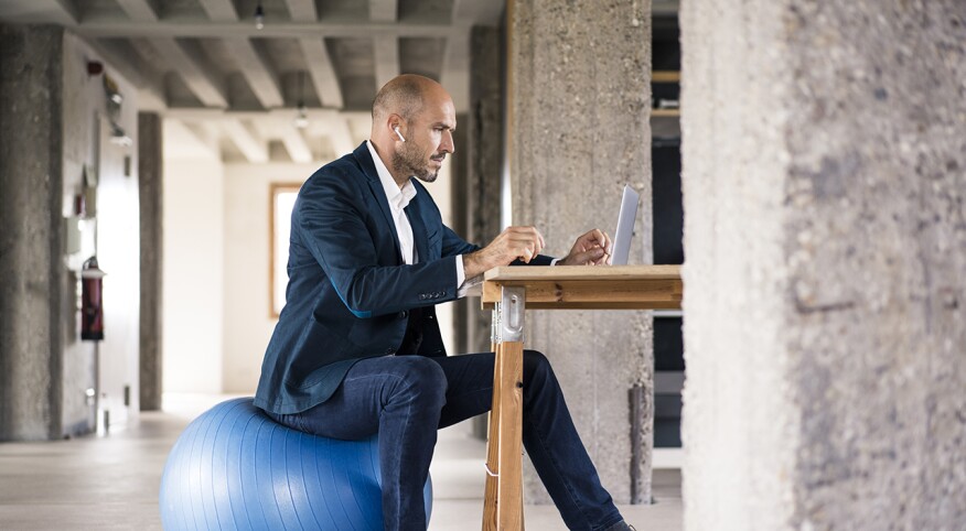 Man at work sitting on fitness ball