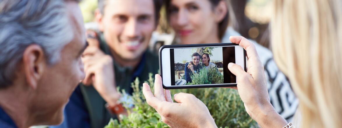 couple taking a photo of another couple on a smartphone