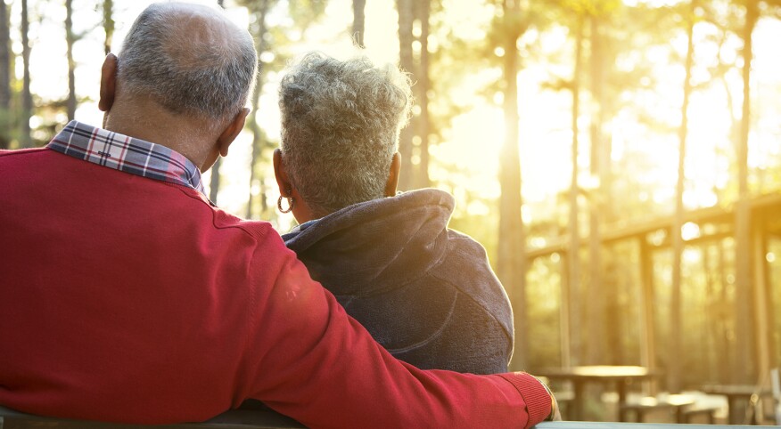 Active senior adult couple enjoy outdoor park at sunset.