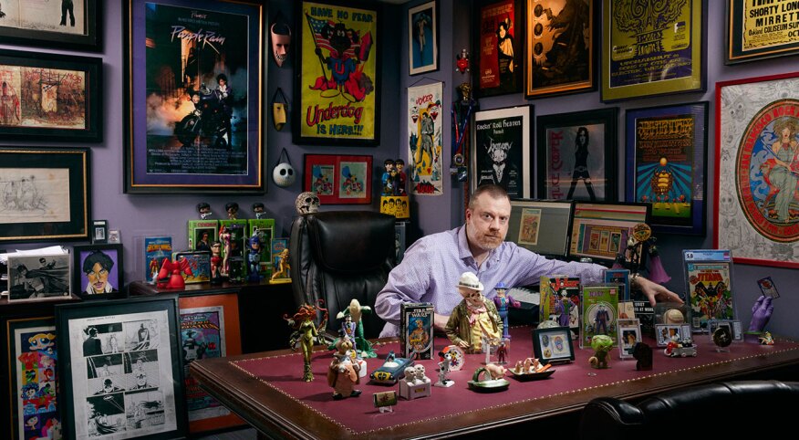 Alex Winter poses with his action figure and comic book collectibles