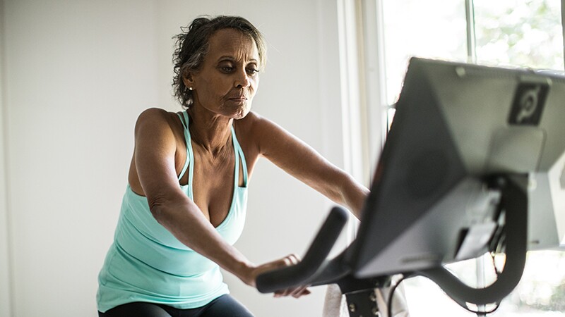A woman exercising on a stationary bike inside a home