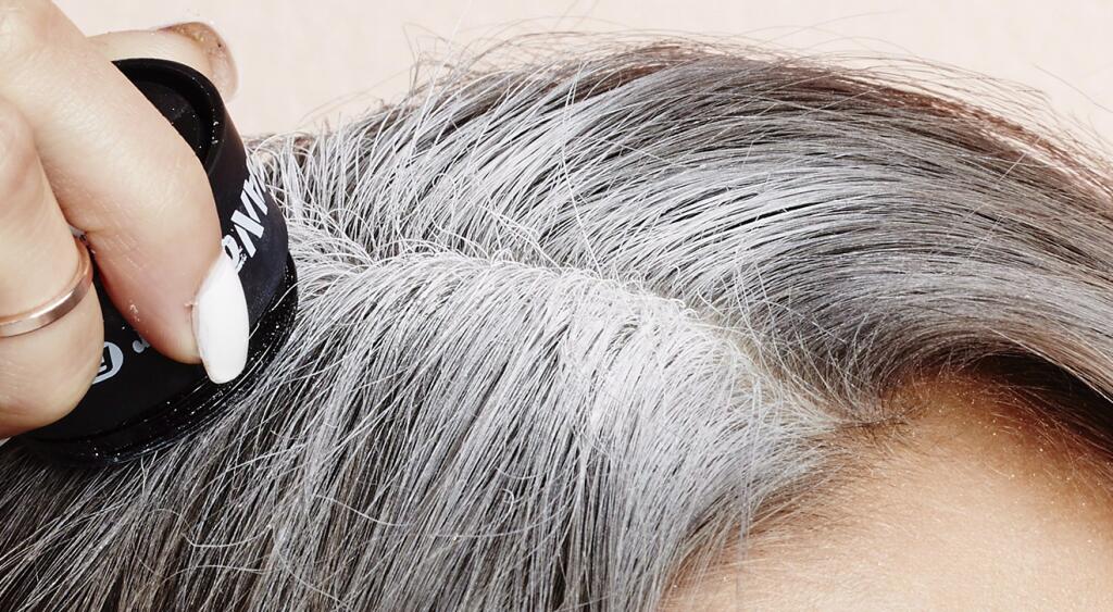 woman touching up her gray roots