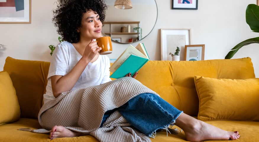 Woman sitting on the couch drinking a coffee