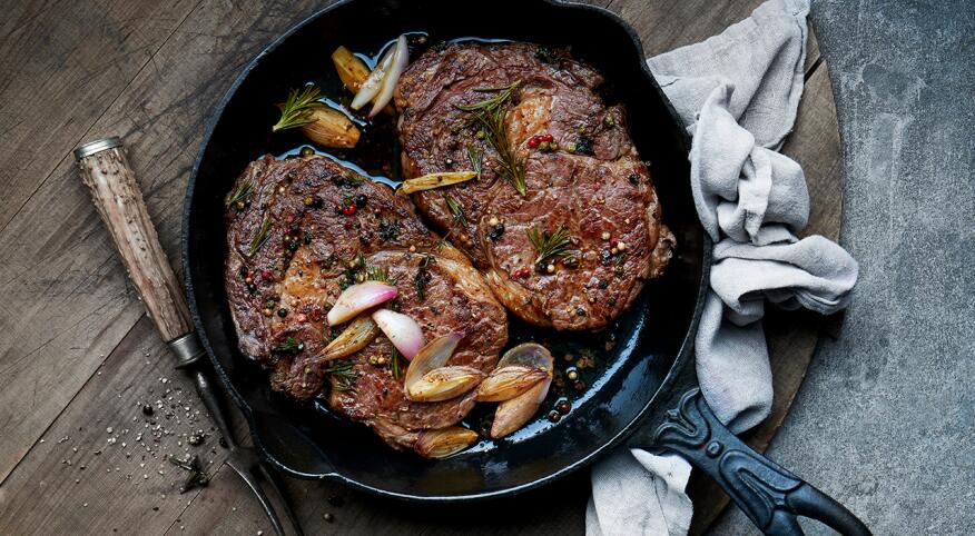 Roasted ribeye steaks in a cast iron pan