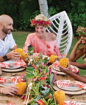 Five adults at Hawaiian-themed birthday celebration