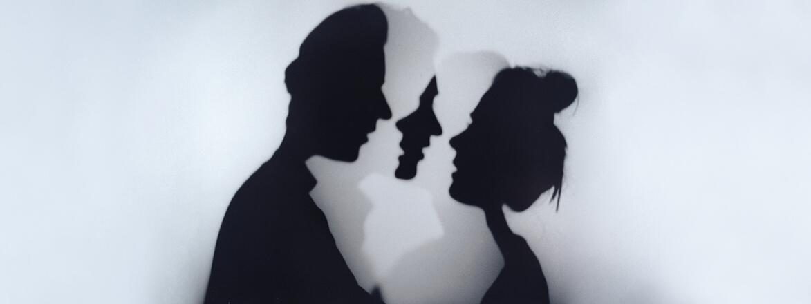 A photo of a woman and man standing face to face.