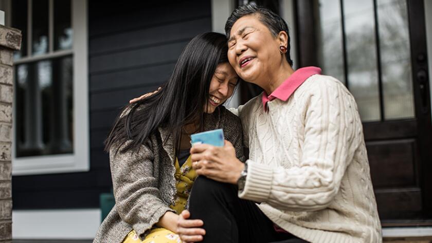 woman and mother hugging on front porch