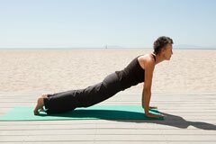 Senior woman doing yoga on beach