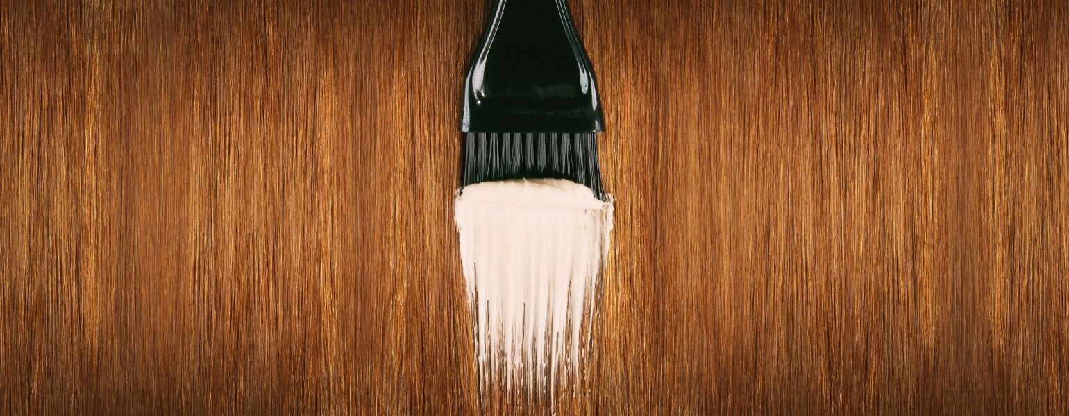 Red hair with brush applying hair dye
