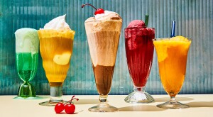 Five colorful ice cream sodas with turquoise background