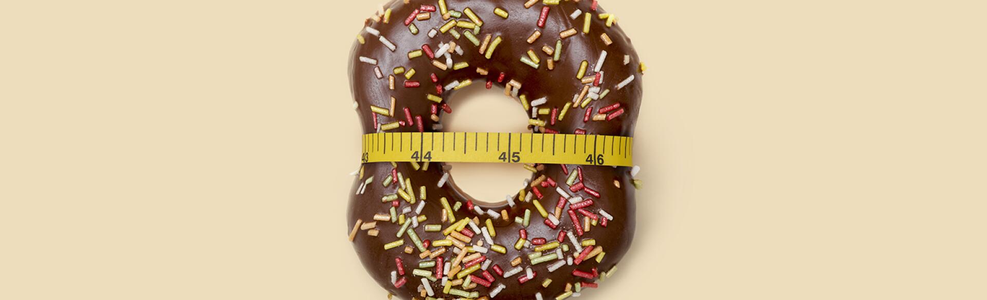 doughnut with measuring tape around it to represent losing weight after menopause