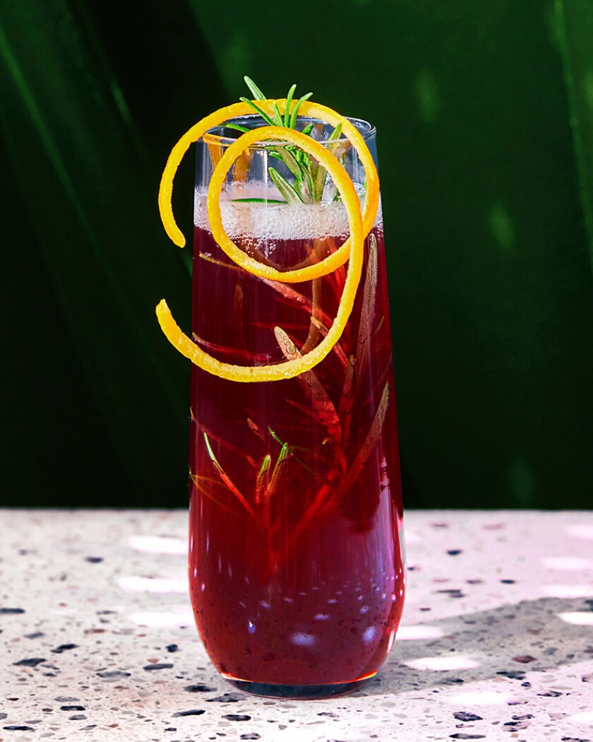 Holiday cocktail on glossy table in front of green curtain