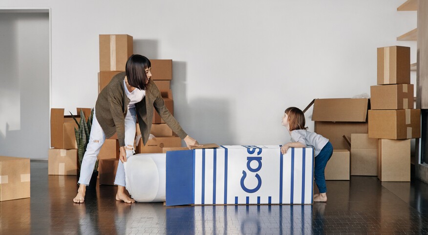 mother and daughter opening casper mattress box at home