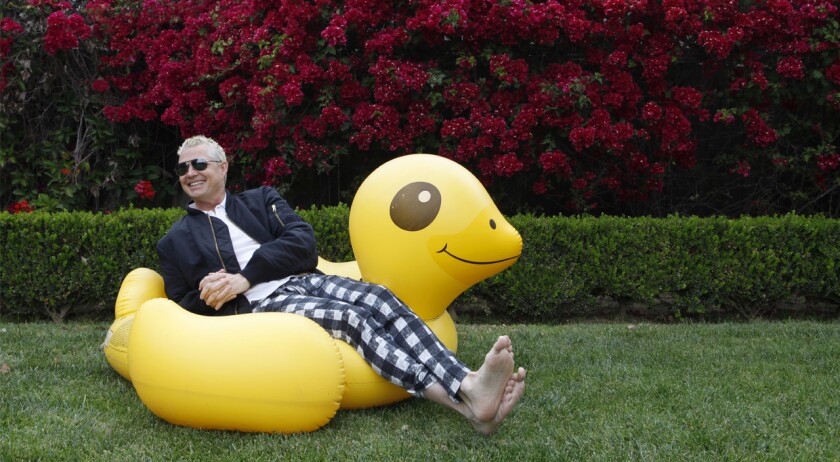 Musician Adrian Young of No Doubt sitting on a pool float in a yard
