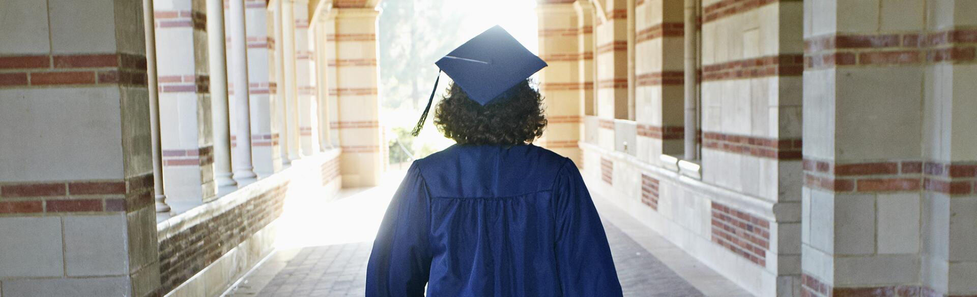 image_of_woman_in_graduate_robe_walking_from_behind_GettyImages-162749395_1800