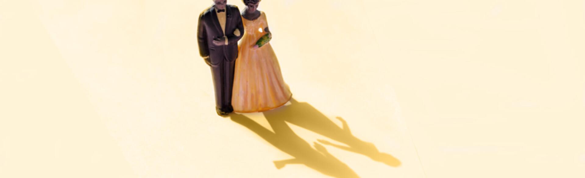 wedding cake topper of couple with shadow showing couple separate