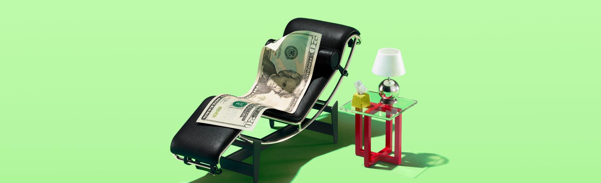 A 20 dollar bill sitting in a tiny therapist chair with a lamp and tissues