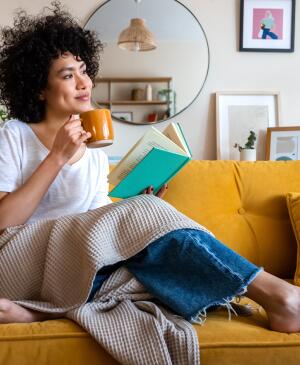Woman sitting on the couch drinking a coffee