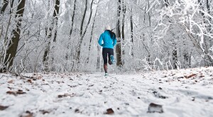 african american woman jogging in a snowy forest