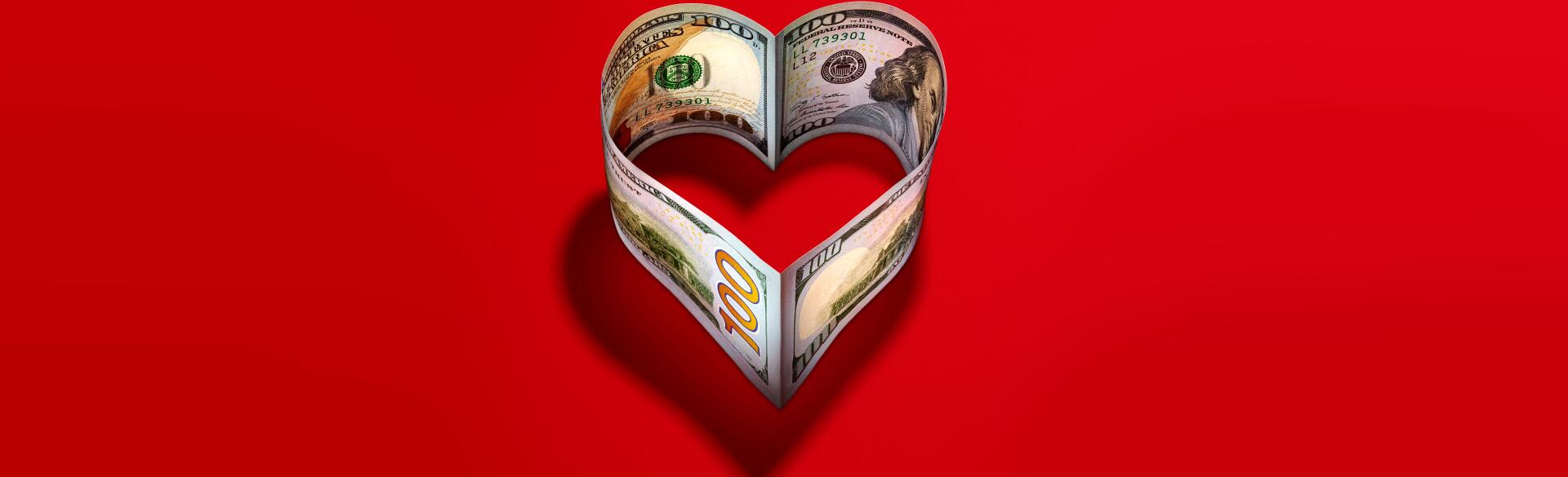 heart made of 100 dollar bills on a red background
