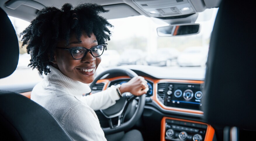 image_of_woman_smiling_behind_car_wheel_shutterstock_1537509677_1800