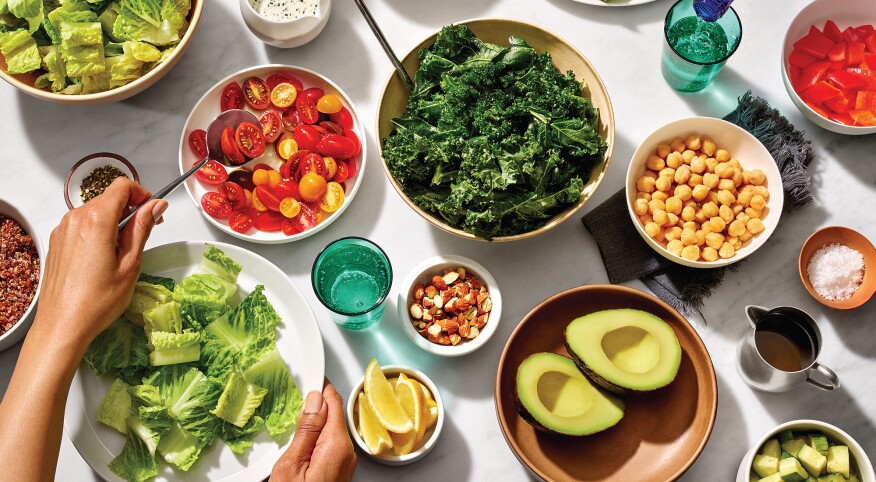 Woman's hands putting together different ingredients to create a salad