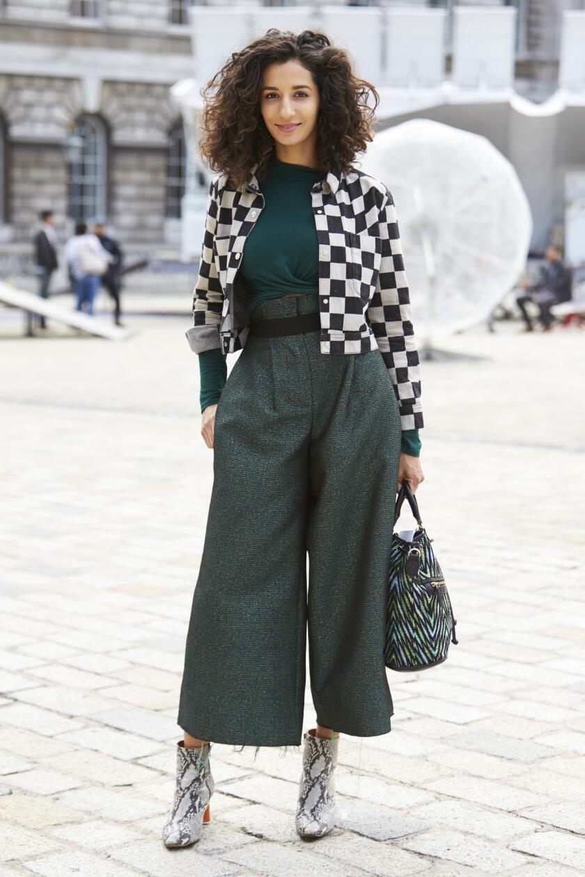 LONDON - 18 SEPTEMBER, 2017: Guest at LFW standing outside Somerset House wearing short black and white check jacket over long sleeved dark green top and culottes with snakeskin ankle boots, Day 4, London Fashion Week.