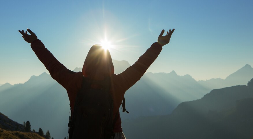 Silhouette of woman from behind enjoying the outdoors in mountains of Italy