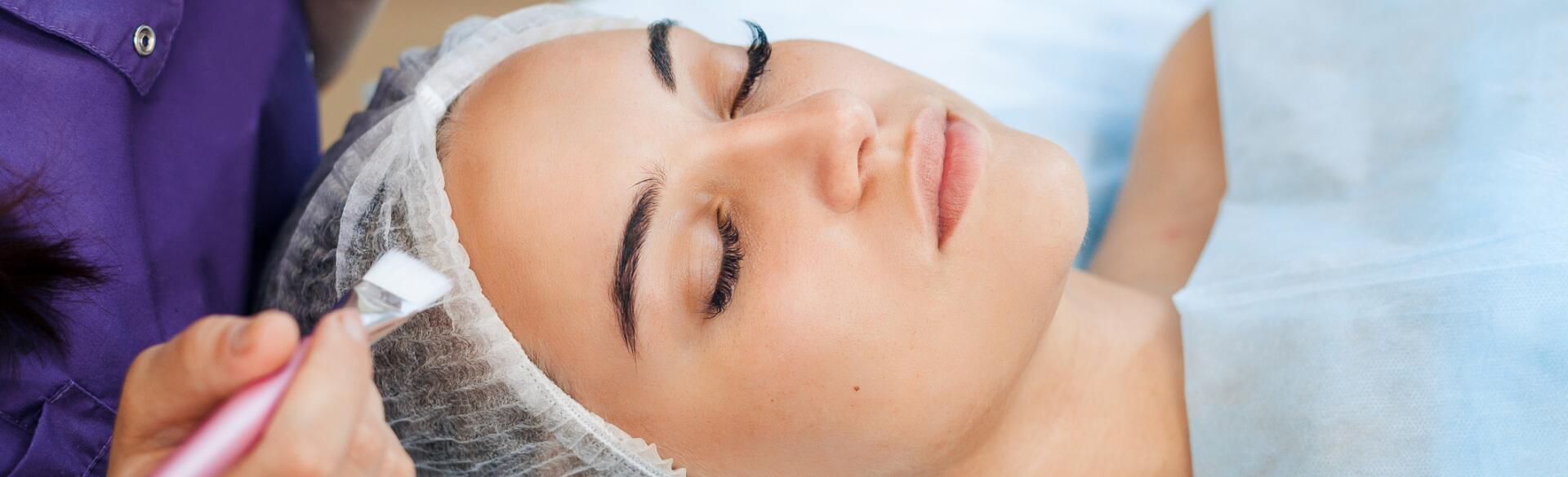 woman getting chemical peel done by cosmetologist