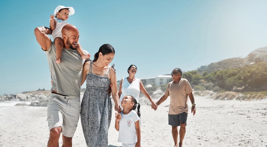 Travel, summer and big family holding hands at beach and walking on vacation, wellness and support together. Smile, love and relax on sea side holiday with happy parents, children and grandparents