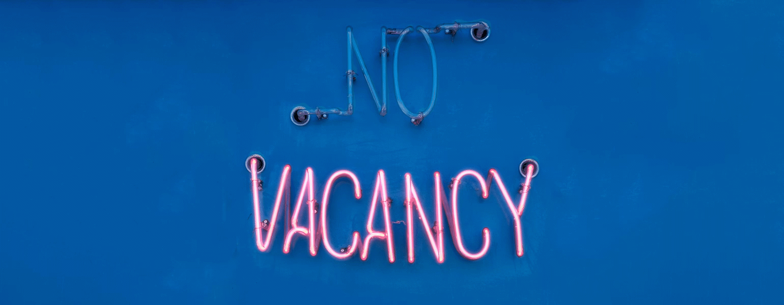 An animated graphic of a neon no vacancy sign, with the no flickering on and off.