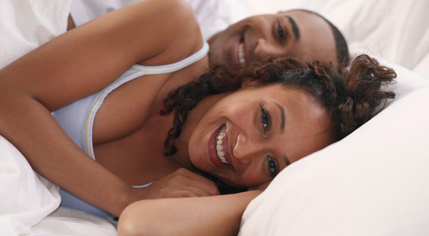 Man and woman cuddling in bed
