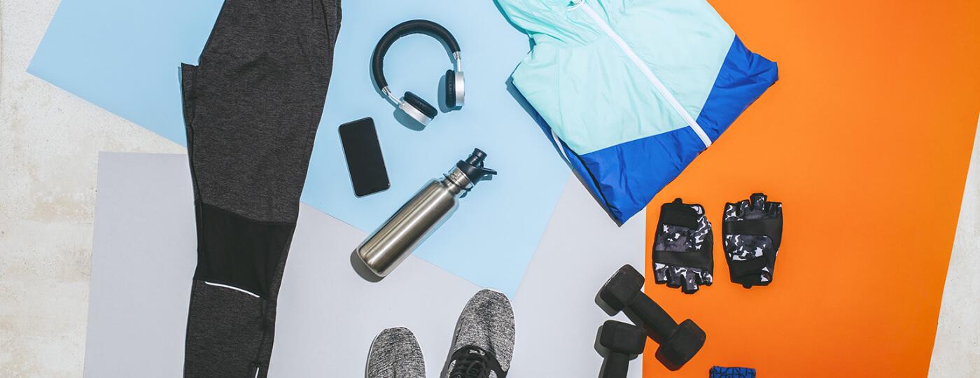 A photo of fitness gear, including sneakers, a workout outfit, a jumprope, and free weights.