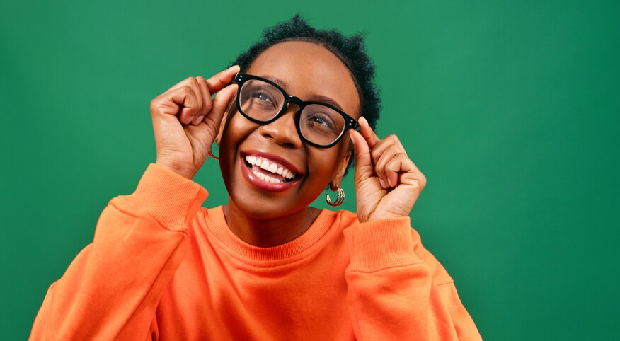 Woman smiling with eye glasses with on a bright green background