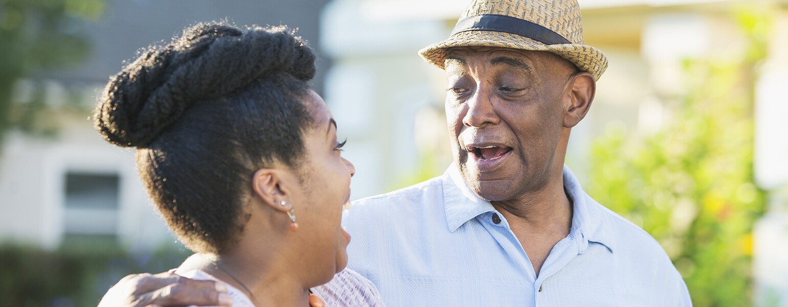 Senior man in front yard with adult daughter