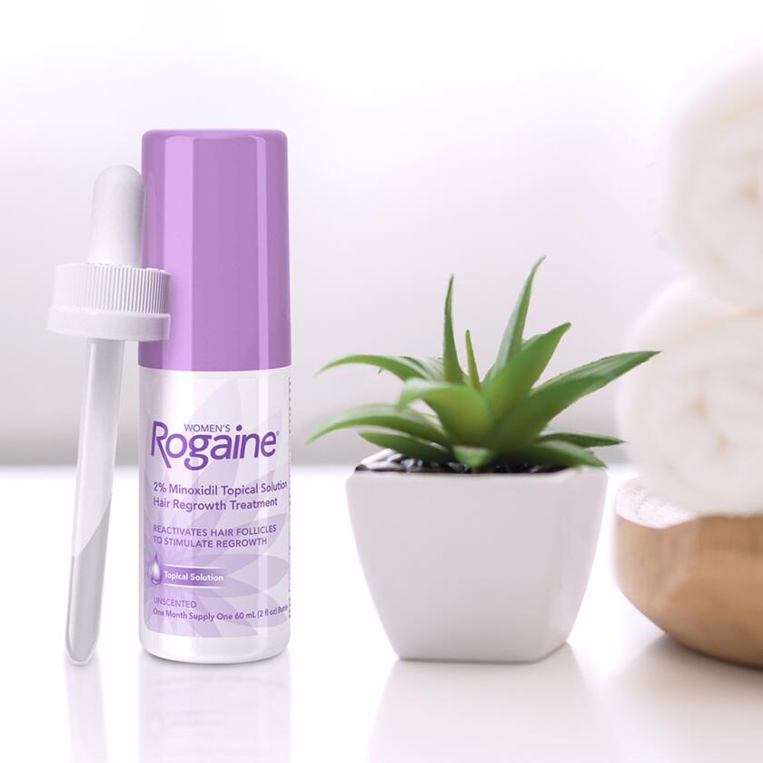 Product shot of Rogaine regrowth hair treatment with plant