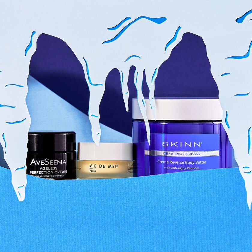 Beauty skincare products styled within cut paper winter scene