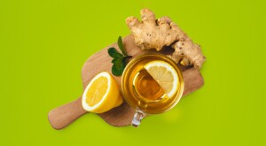 ginger, tea and lemon on green background