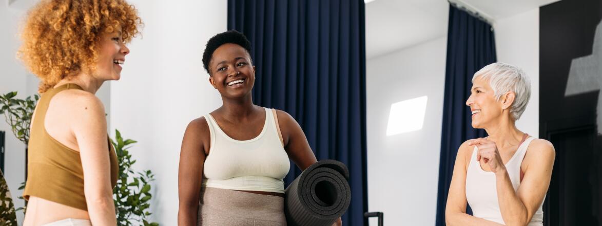 Three friends chatting in a Pilates Studio