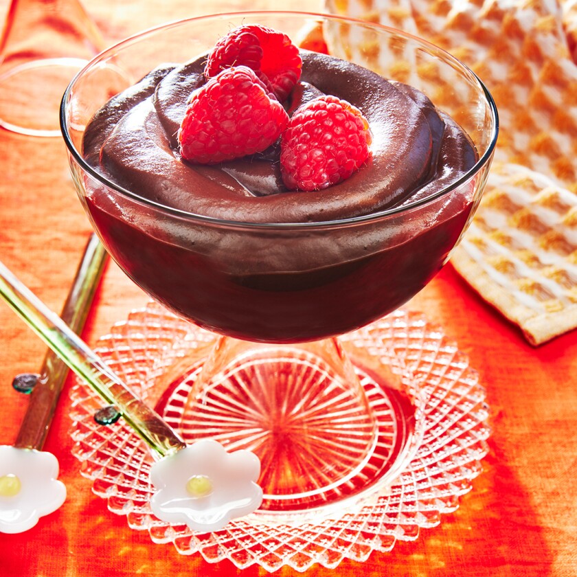 Glass bowl of Chocolate Mousse garnished with bright raspberries