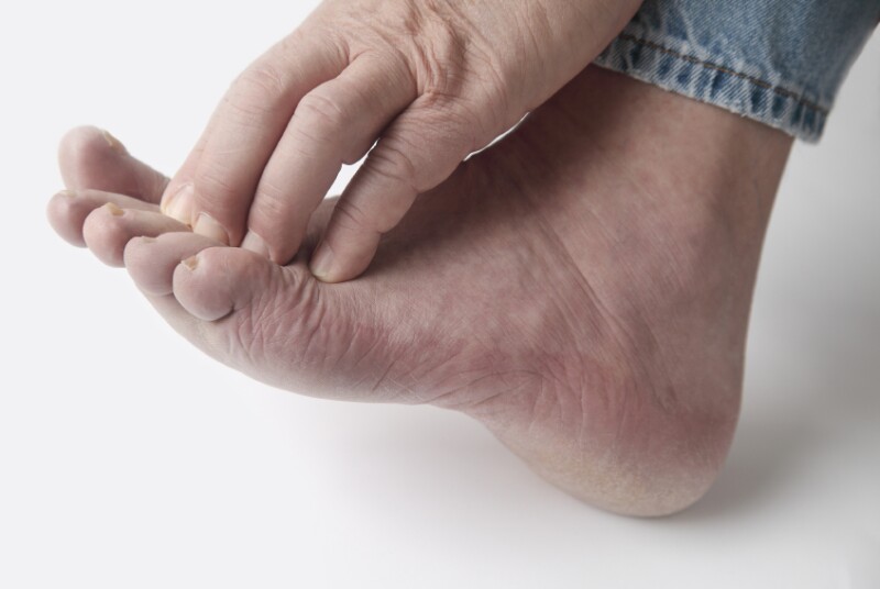 Hand scratches itch on foot