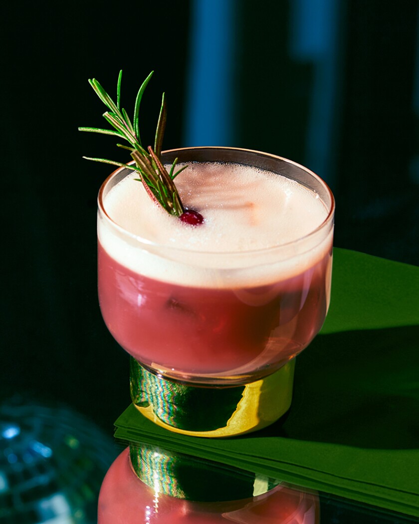 Holiday cocktail on glossy table in front of green curtain