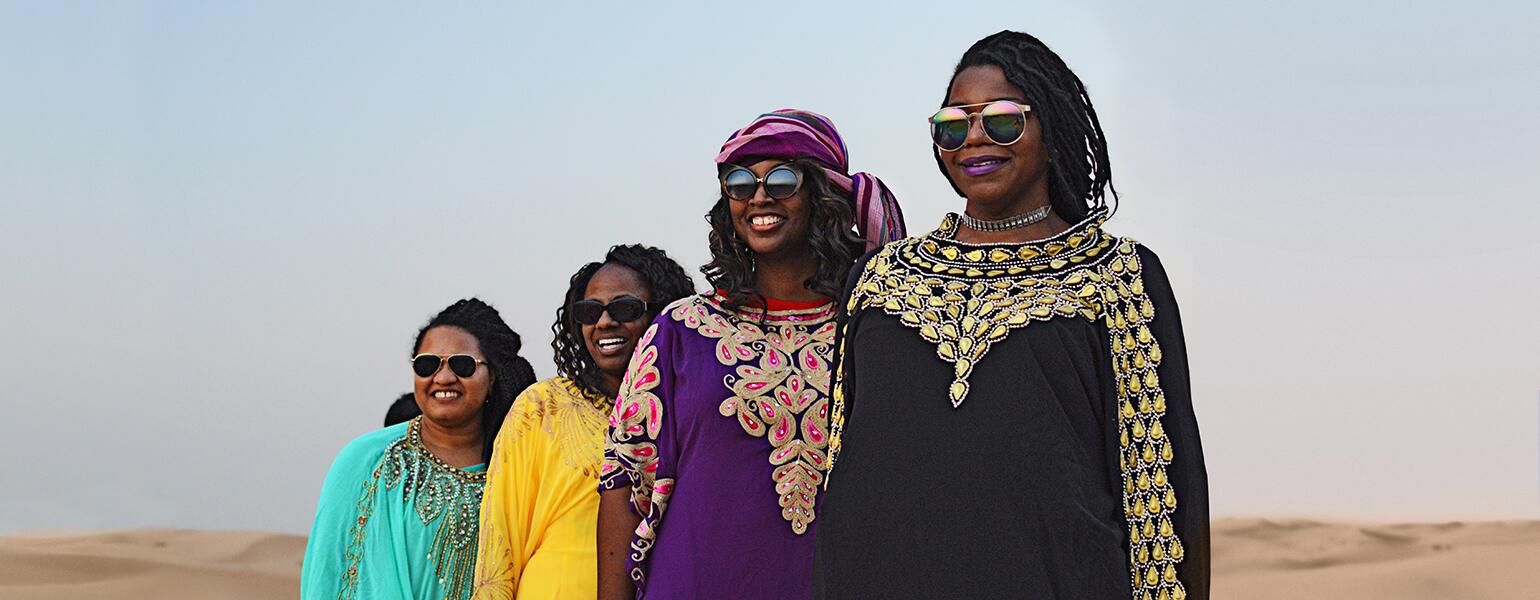 A group of four women stand in the UAE desert near Abu Dhabi.