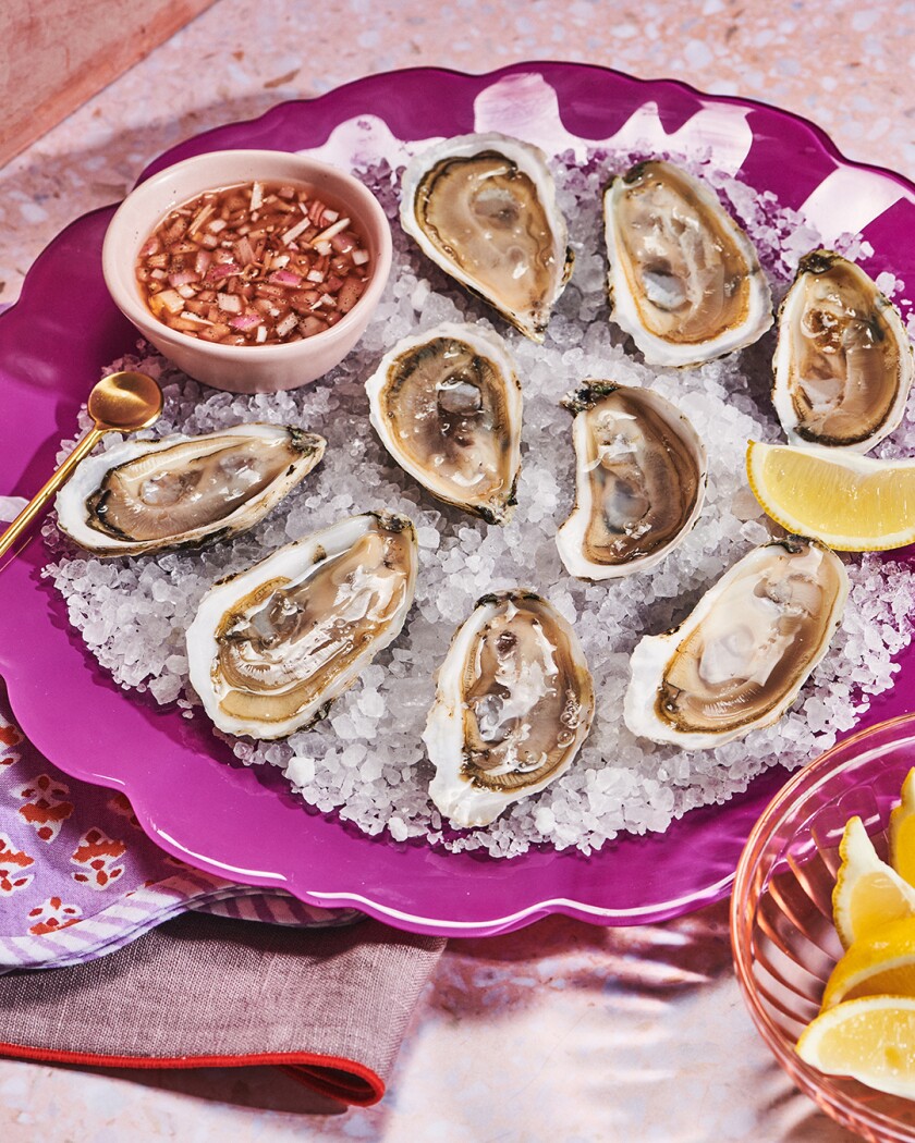 Raw oysters on the half-shell -with a special sauce on a pink plate for Valentine's Day
