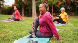 three women, on grass, practicing yoga, photograph
