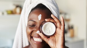 image_of_woman_holding_moisturizer_over_face_GettyImages-1280517978_1800