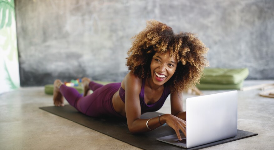Woman on her laptop at home taking online fitness classes