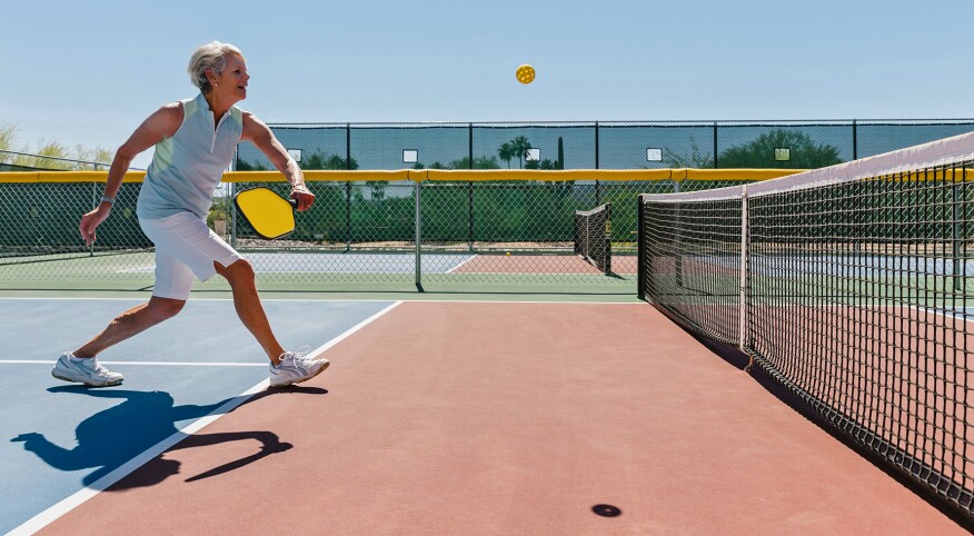 Woman at the net of a pickleball court 