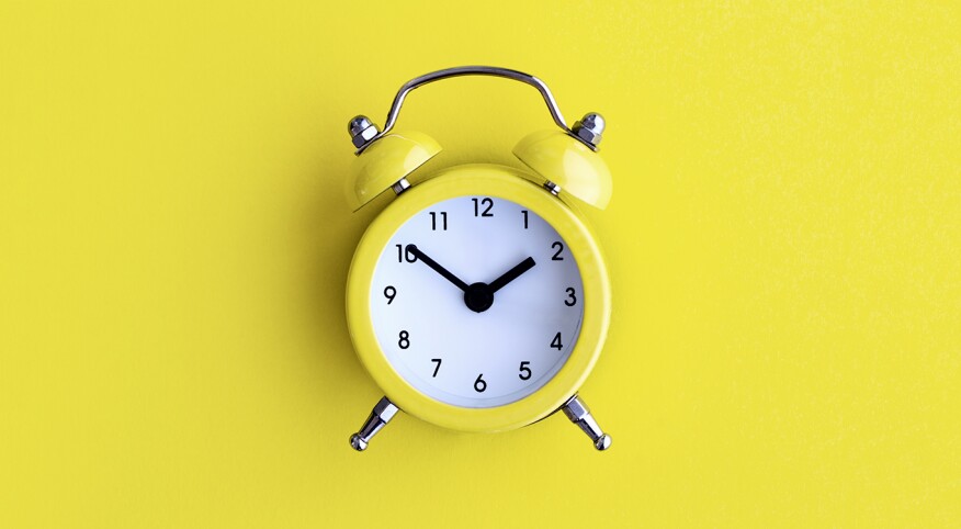 yellow alarm clock on a yellow background