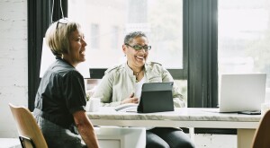 Laughing mature female business partners in meeting in office